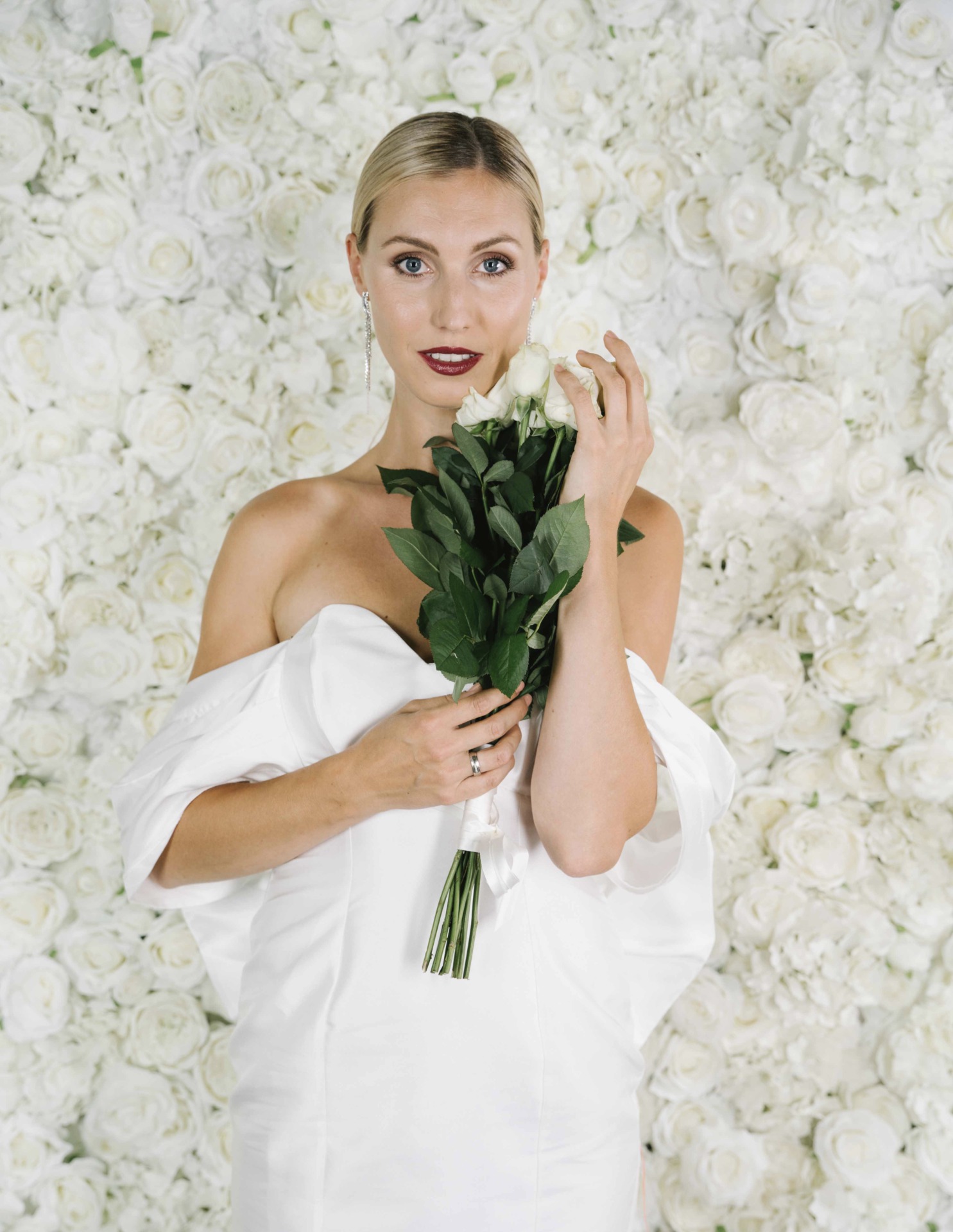 Sexy Braut vor Blumenwand Pearl White Rosengold