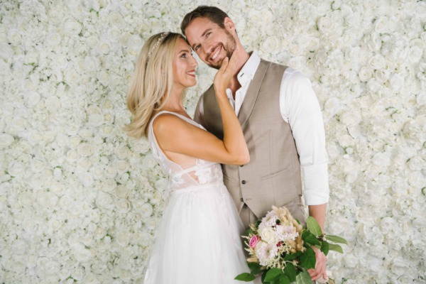 Brautpaar Lächelnd vor Blumenwand Weiß, Pearl White