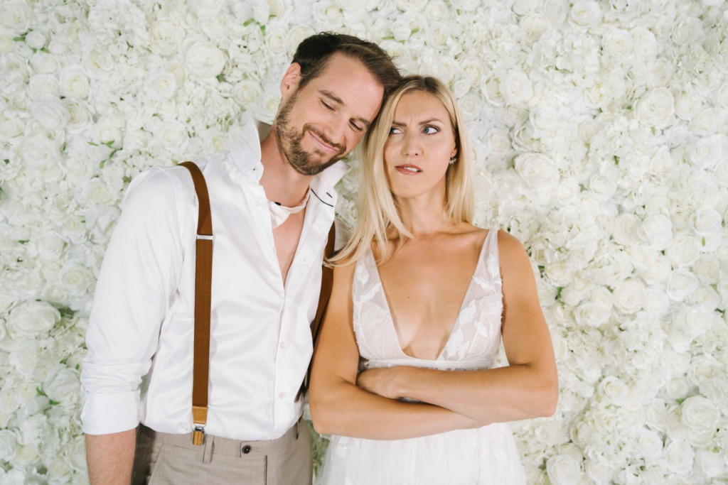 Brautpaar witzig vor Blumenwand Pearl White Rosengold